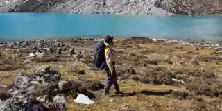 Trekker near turquoise lake on EBC trail