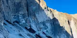 Trekkers navigating a rugged trail surrounded by prisitne mountain views