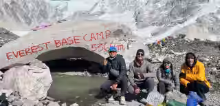 Proud trekkers at 5364m Everest Base Camp marker