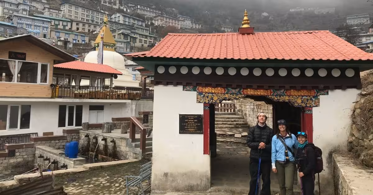 Trekkers posing at the entrance gate of Namche Bazaar Monastery