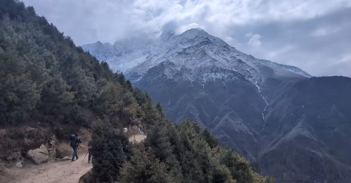 Hikers walking the EBC trail in October with snow on mountain peaks
