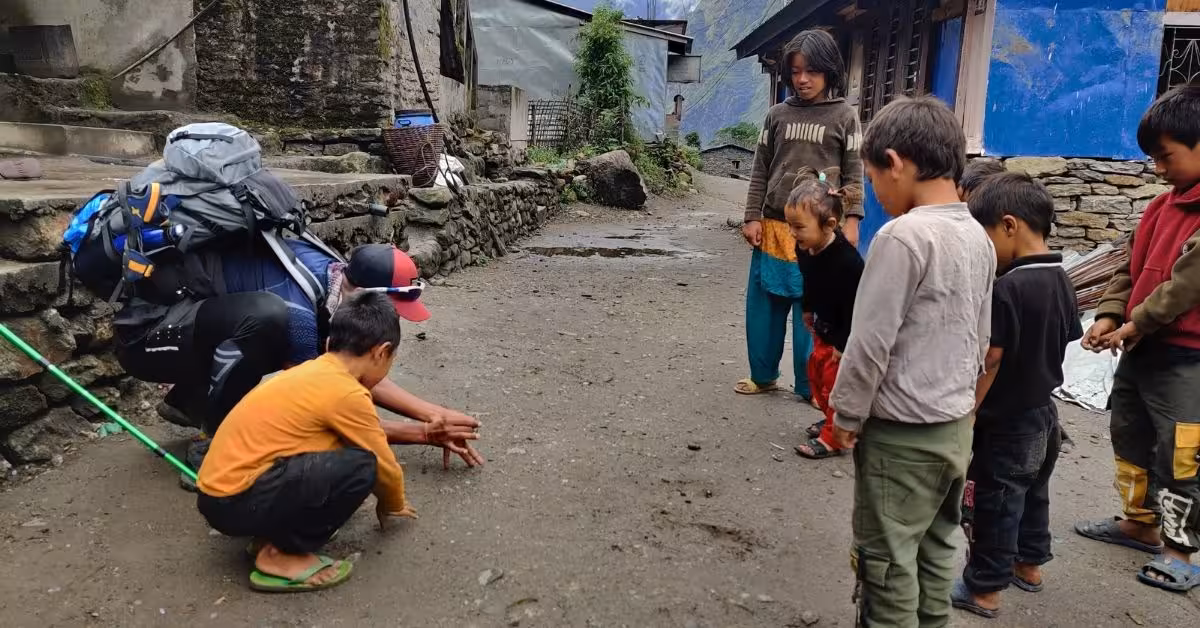Local children playing games in a mountain village with trekkers