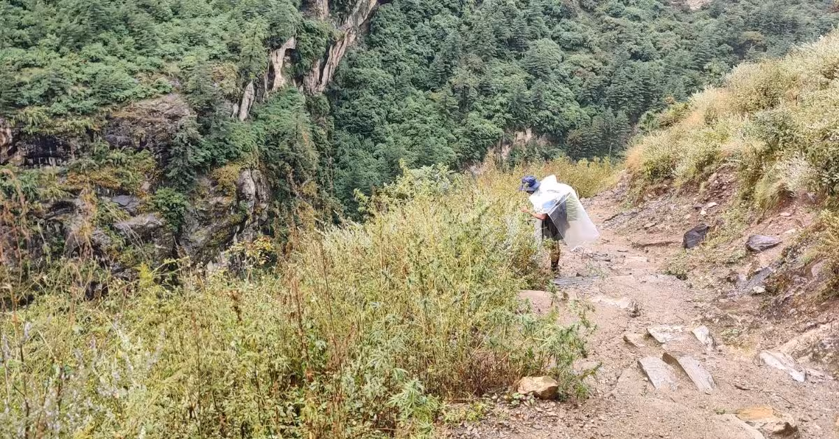 Hiker on a narrow cliffside path in Manaslu region