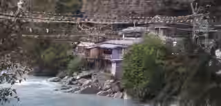 Riverside guesthouses with prayer flags in Annapurna