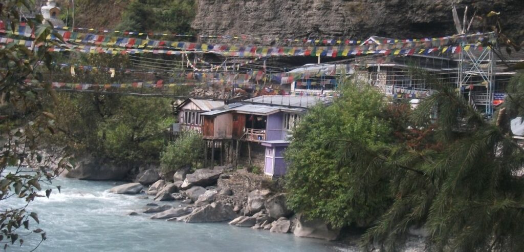 riverside guesthouses with prayer flags in annapurna